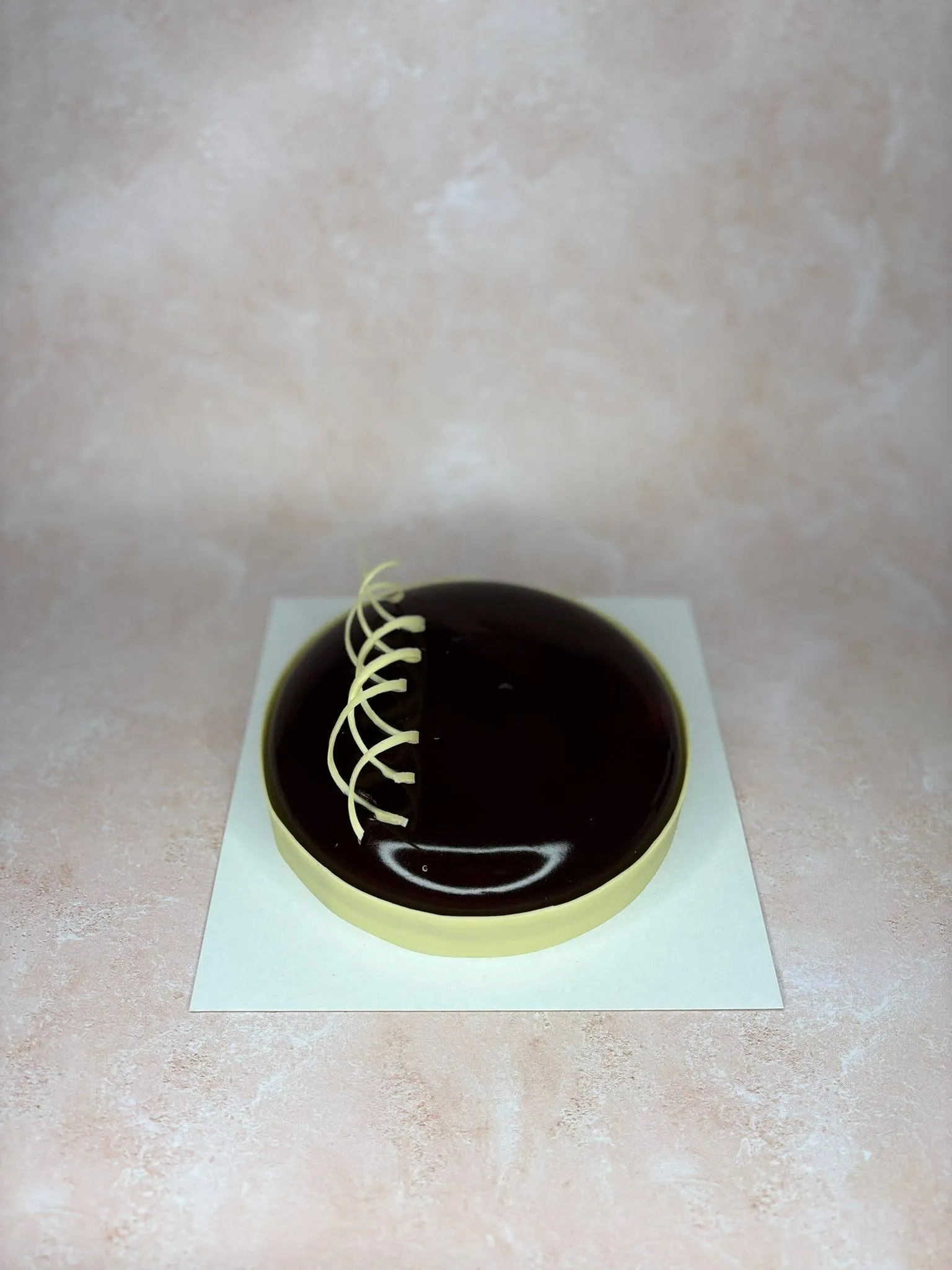 Entremets glaçage miroir chocolat noir, décor fileté blanc