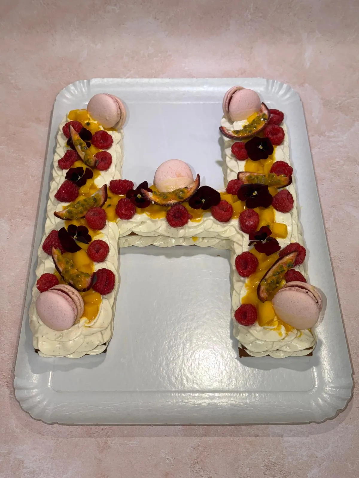 Letter cake H, framboises, fruits exotiques et macarons