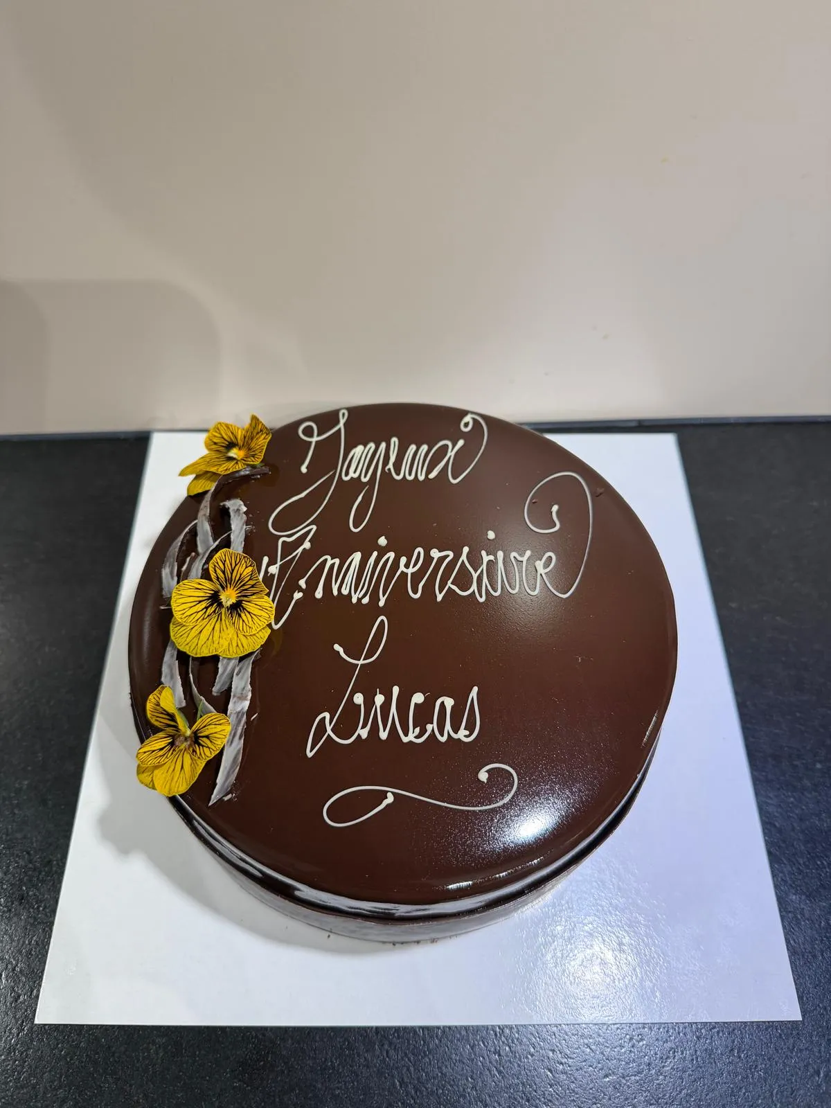 Entremets anniversaire glaçage chocolat, inscription personnalisée et fleurs