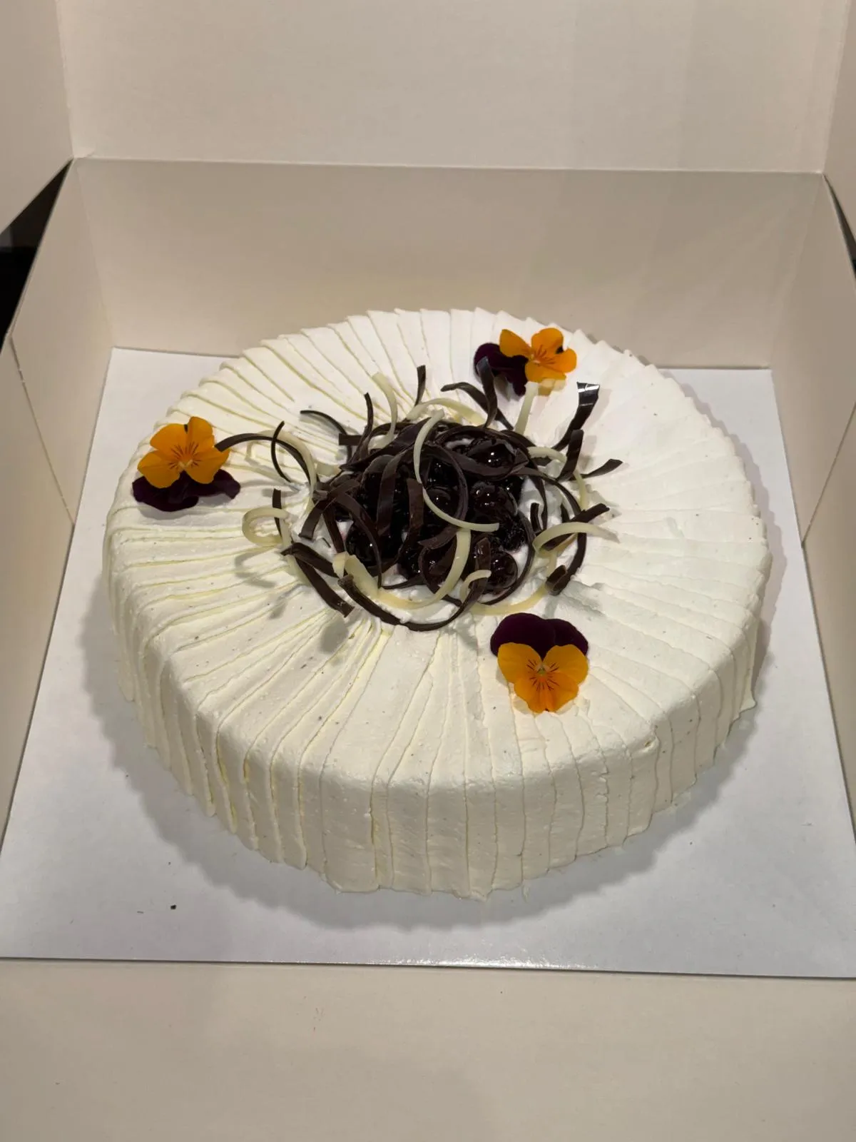 Entremets crème plissée, nid de copeaux de chocolat et fleurs comestibles