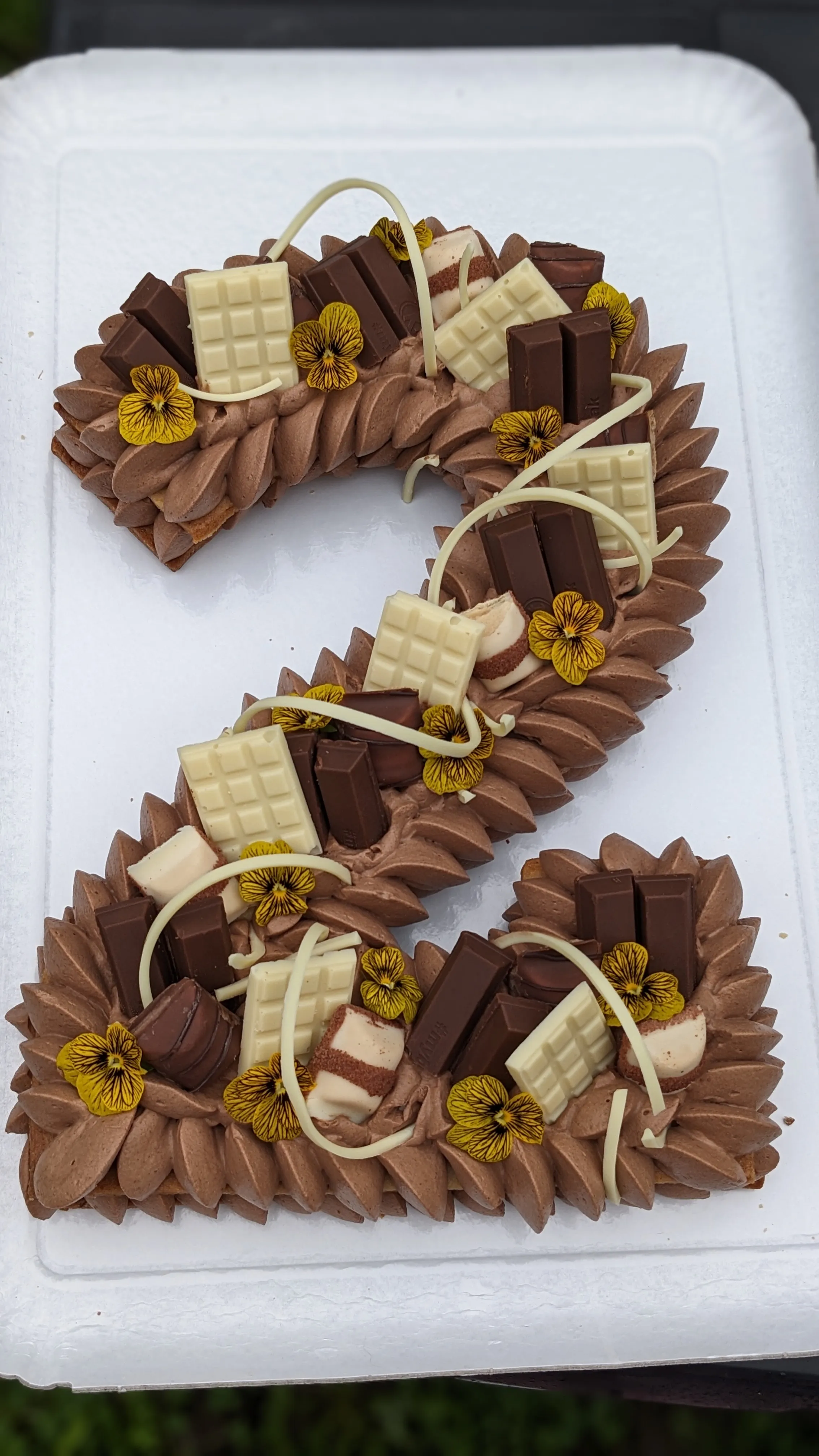 Number cake chocolat, gros plan sur le décor et fleurs jaunes